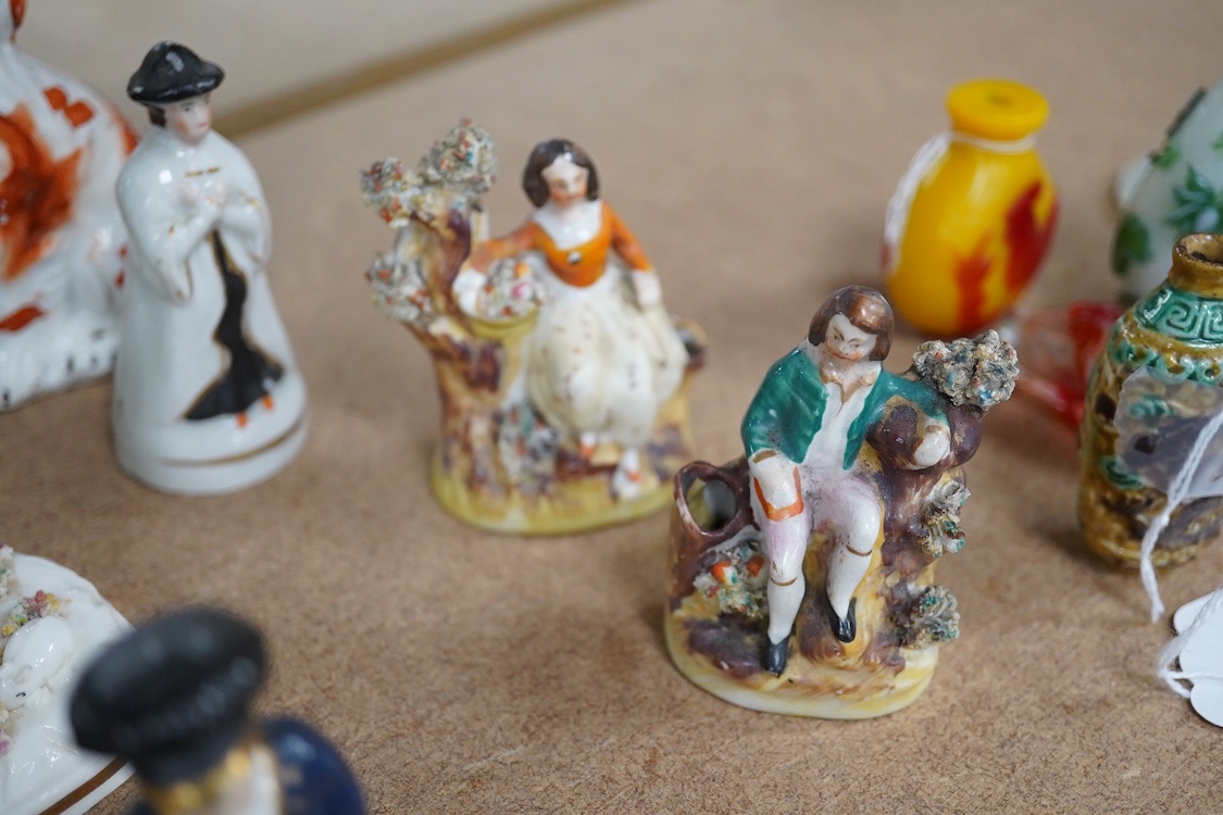 A collection of 19th century and later Staffordshire figures, mostly figural examples, including a pair a rare pair of porcelain seated figures with rabbits and a candle extinguisher, largest 15cm high (15)